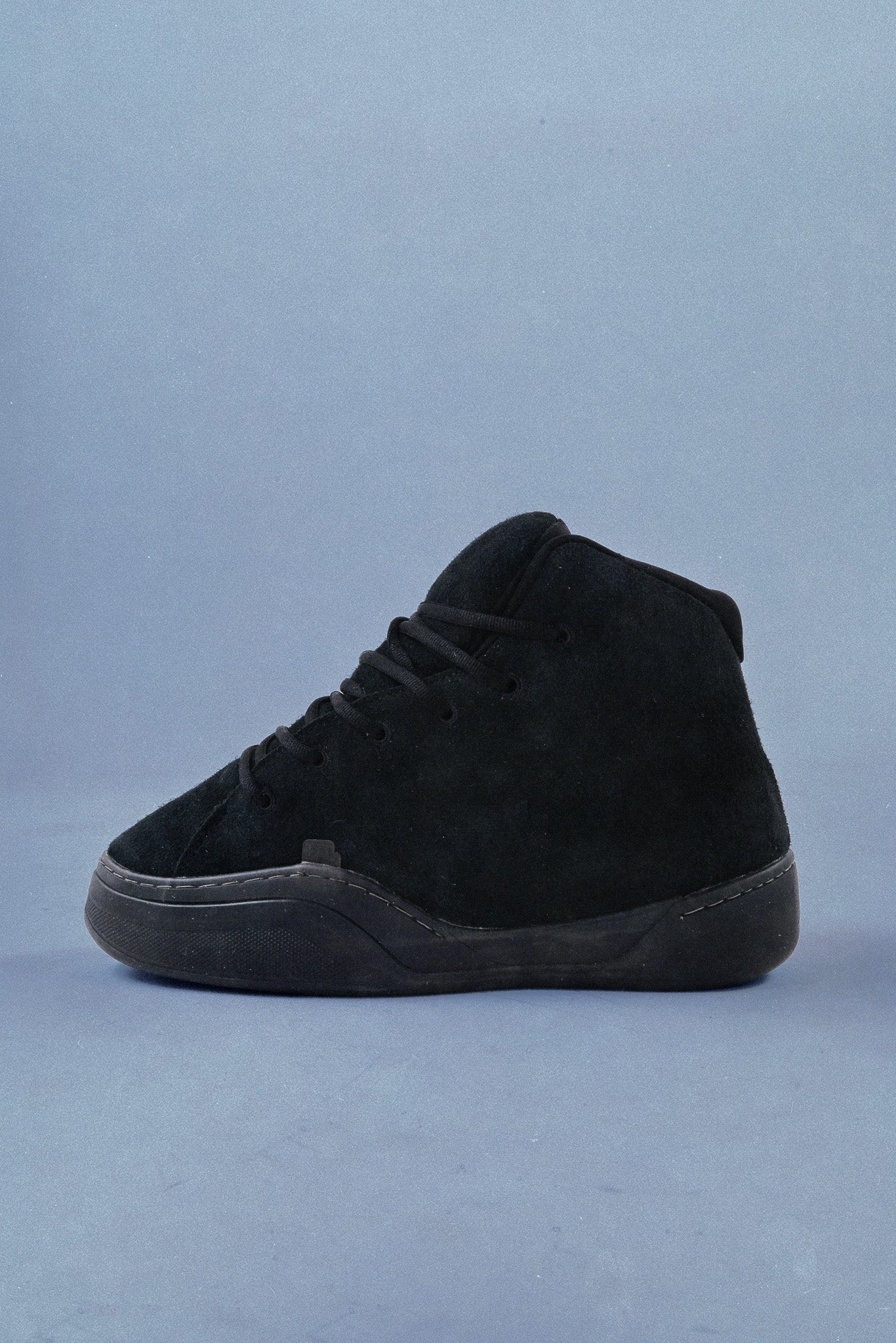 Black high-top sneaker on a light blue background