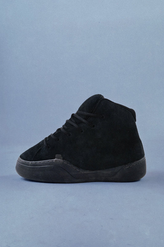 Black high-top sneaker on a light blue background